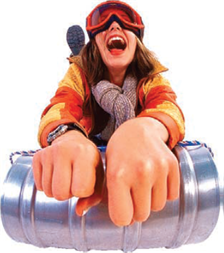 Woman wearing snow goggles while she rides a  toboggan. 